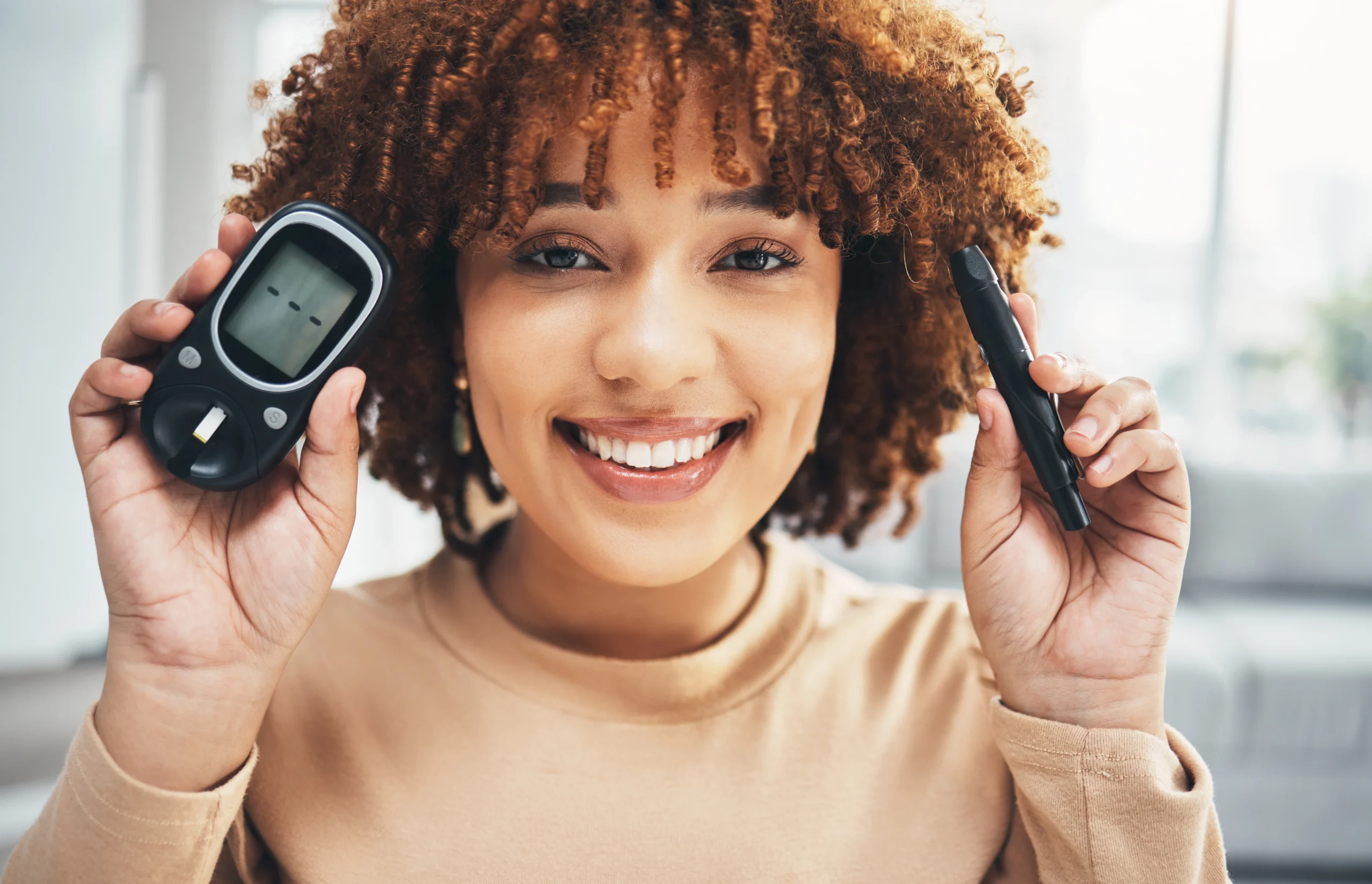 Happy smiling woman holding a blood glucose meter showing glucose levels